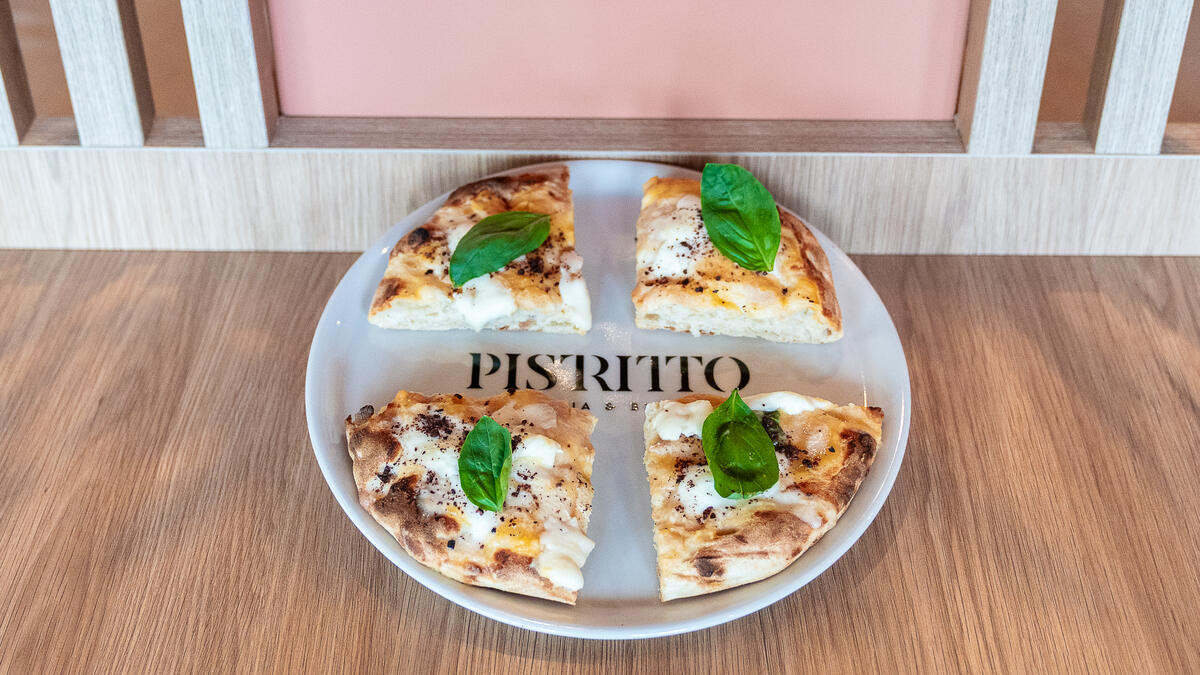 Pizza servita sul piatto con il logo Pistritto